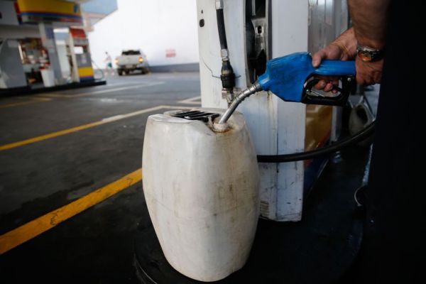 Frentista abastece galão (foto Fernando Frazão , abr)