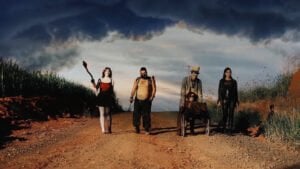 Quatro pessoas caminhando em estrada de terra, capa de filme presente na mostra internacional de cinema fantástico