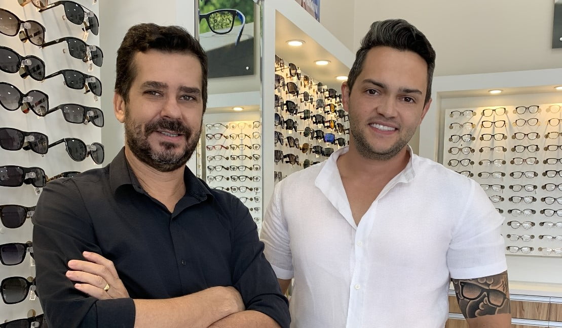 Dois homens em frente uma vitrine de óculos no lançamento da Cartier