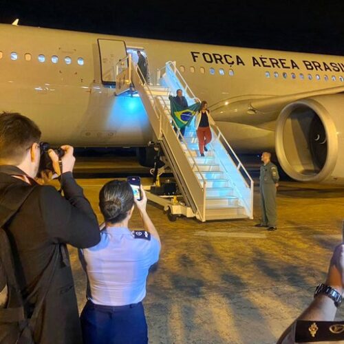 Desembarque dos primeiros brasileiros repatriados na Base Aérea de Brasília: bandeira nacional em punho, em segurança. Foto: Vinicius Neves / Secom / PR